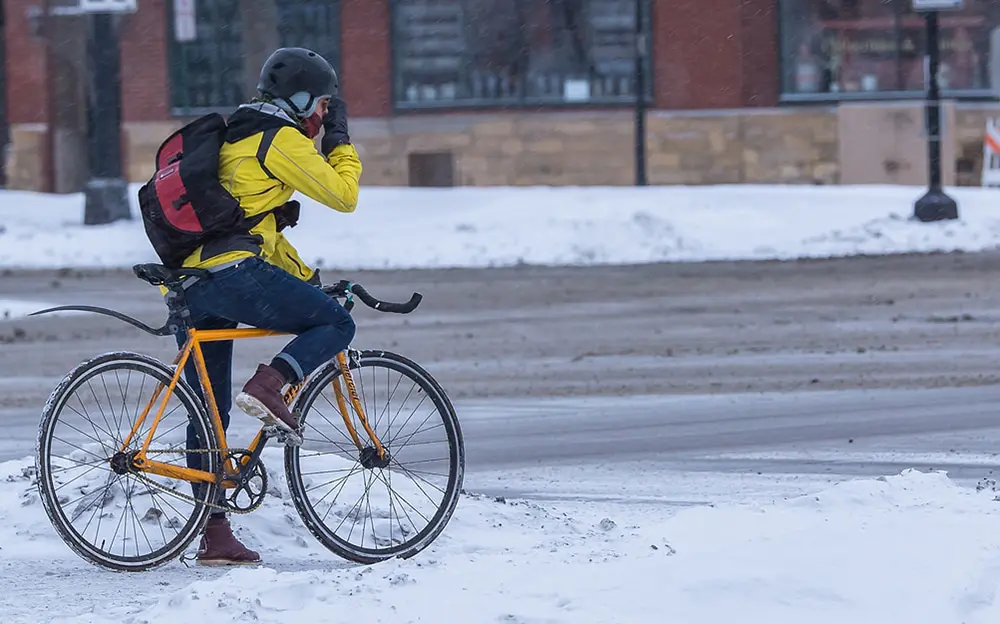 Un cycliste en vélo fixie qui roule dans la neige