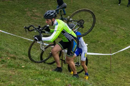 Ludo à pied avec son vélo de cyclocross sur l'épaule pour monter une pente très raide