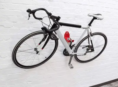 Un vélo accroché au mur par sa pédale