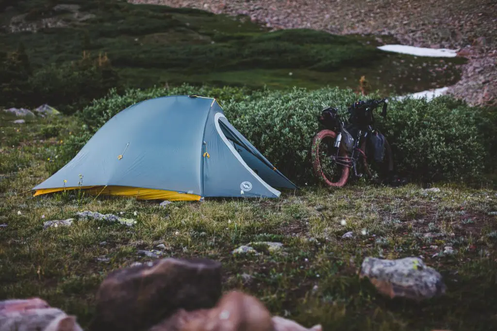 Un vélo à côté d'une tente de camping lors d'un voyage