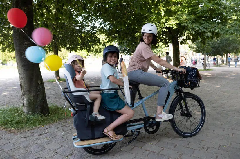 Vélo cargo longtail avec 2 enfants à l'arrière et une conductrice