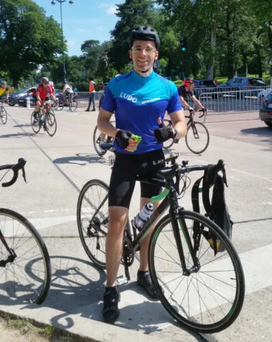 Le cycliste Ludo sur son vélo noir Btwin avec une compote dans les mains