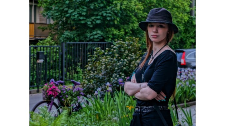 Une femme avec un chapeau devant son vélo