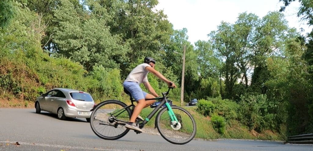 Un cycliste dans un épingle à gauche avec le vélo Tenways penché vers l'intérieur de la route