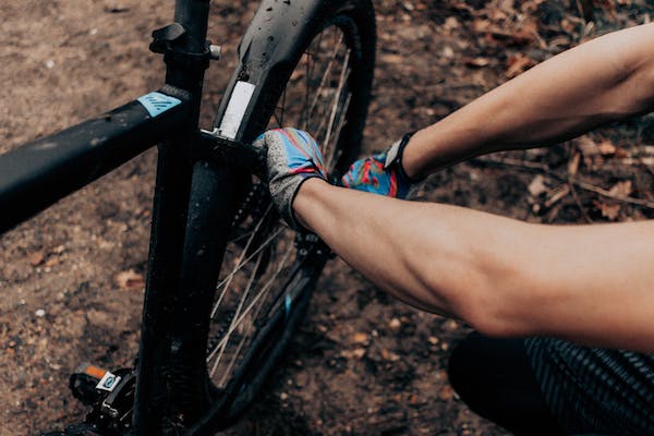 Une personne qui répare une roue de son vélo
