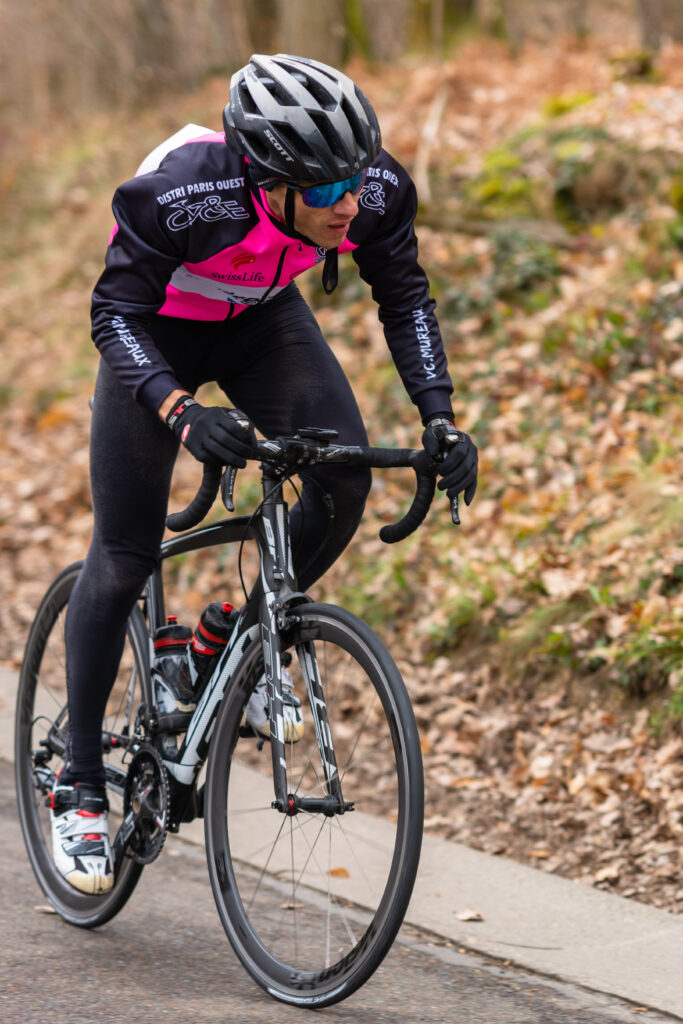 Cycliste avec les mains sur les cocottes pour monter une bosse plus facilement