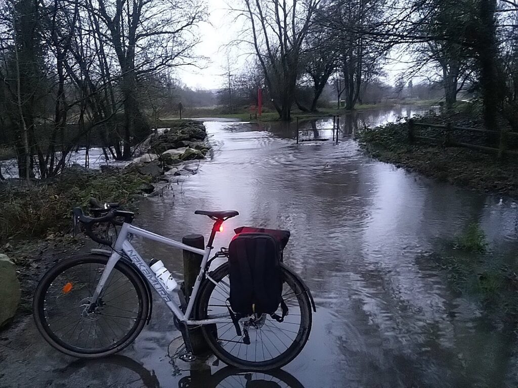Le vélo avec sac sur les portes-bagages avec de l'eau en arrière plan