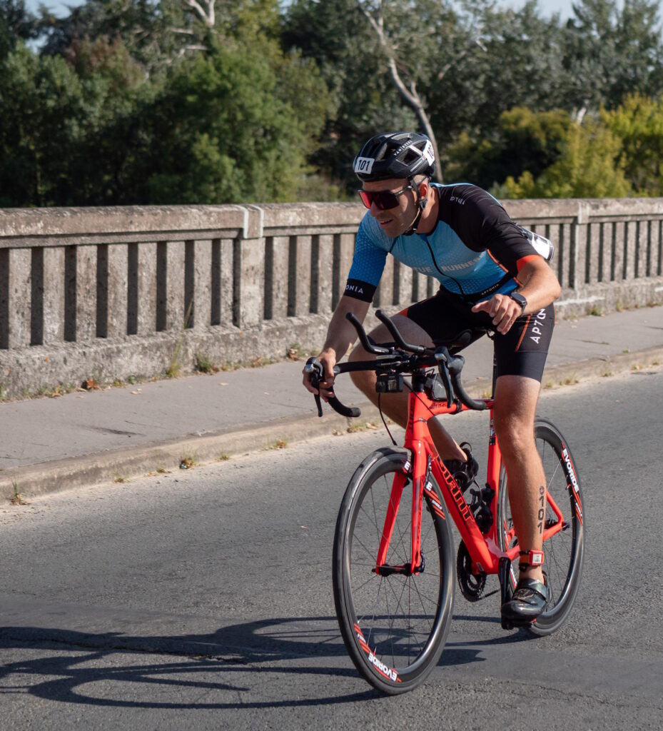 Le cycliste lève la main pour saluer lors d'un triathlon sur son vélo Giant Propel