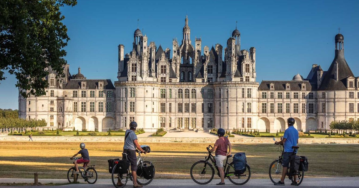 Famille de cyclistes devant un joli château de la Loire