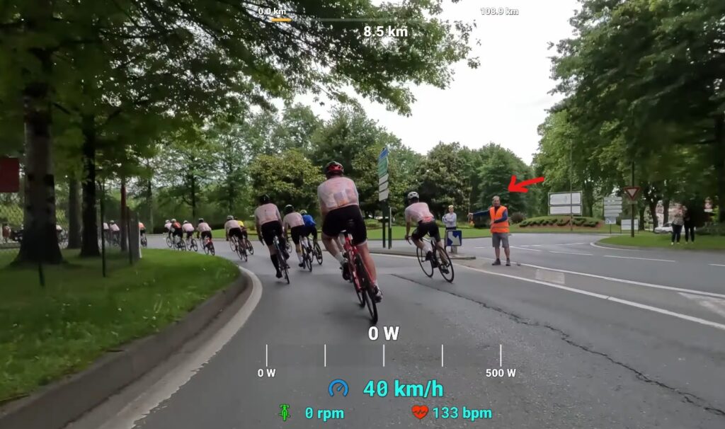 Un bénévole signale le virage à gauche à prendre à vélo